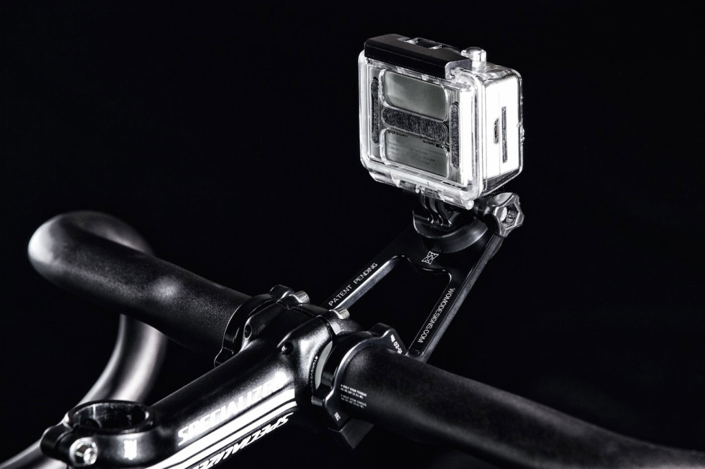 A dark photo of bike handlebars with a GoPro camera mounted.